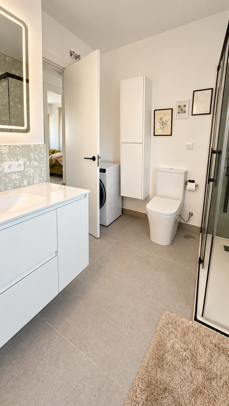 Baño del proyecto Cazorla 89 con mueble suspendido blanco, zona de lavado y detalles botánicos